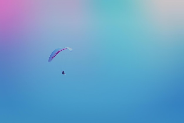 Hombre volando un parapente en el cielo tonificado