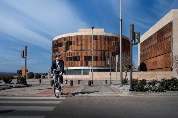 Hombre yendo a trabajar en bicicleta con casco tiro largo