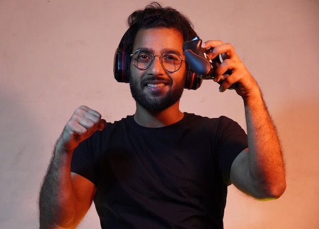 Hombre de Yong con joystick del juego y usando auriculares