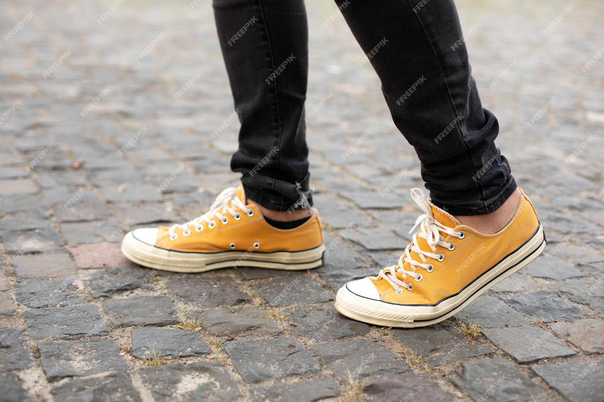 Hombre con zapatillas amarillas caminando por la | Foto Premium