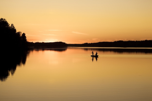 Hombres árbol pescando en un barco en el río Vuoksa