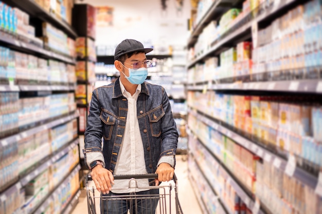 Hombres asiáticos compran y compran alimentos para acaparar durante el brote de Covid