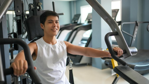 Hombres asiáticos haciendo ejercicio de pecho en el gimnasio