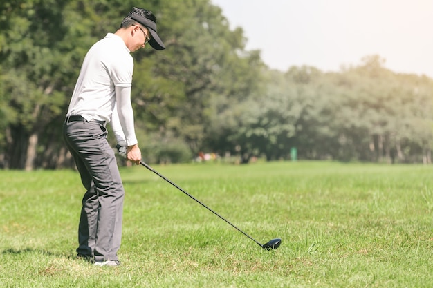 Hombres asiáticos jugando al golf. los hombres juegan al golf mientras están de pie en el campo