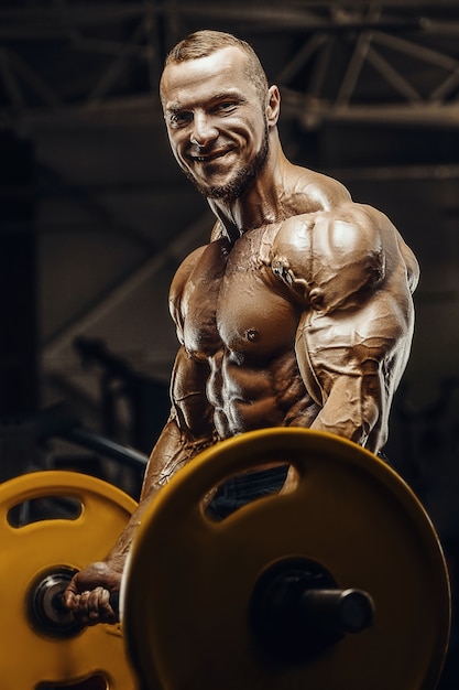 Hombres atléticos fuertes guapos bombeando los músculos bíceps entrenamiento fitness y concepto de culturismo