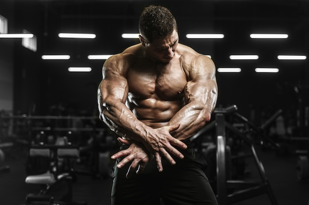 Hombres atléticos fuertes y guapos bombeando músculos concepto de culturismo entrenamiento