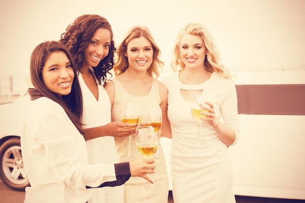 Foto hombres bien vestidos bebiendo vino junto a la limusina en la noche