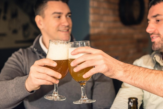 Foto hombres brindando con un vaso de cerveza