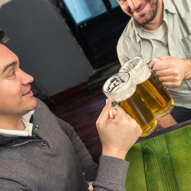 Foto hombres brindando con un vaso de cerveza