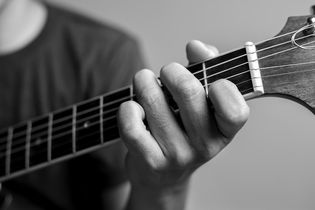 Los hombres captan acordes están aprendiendo a tocar la guitarra. Los músicos de primer plano están captando acordes de guitarra. Los músicos masculinos sostienen acordes y rasguean la guitarra.