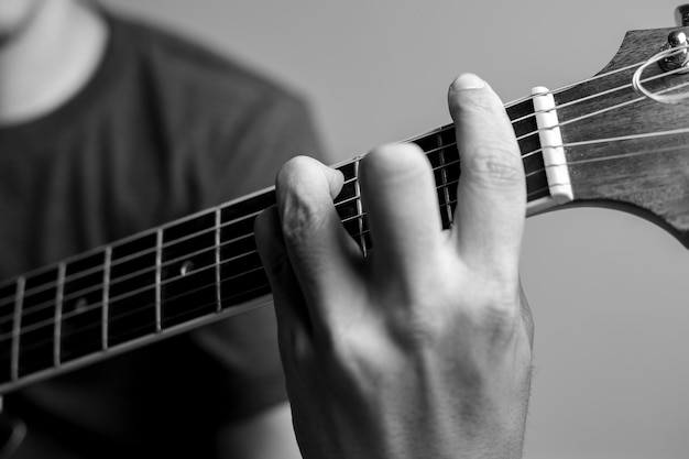 Los hombres captan acordes están aprendiendo a tocar la guitarra. Los músicos de primer plano están captando acordes de guitarra. Los músicos masculinos sostienen acordes y rasguean la guitarra.