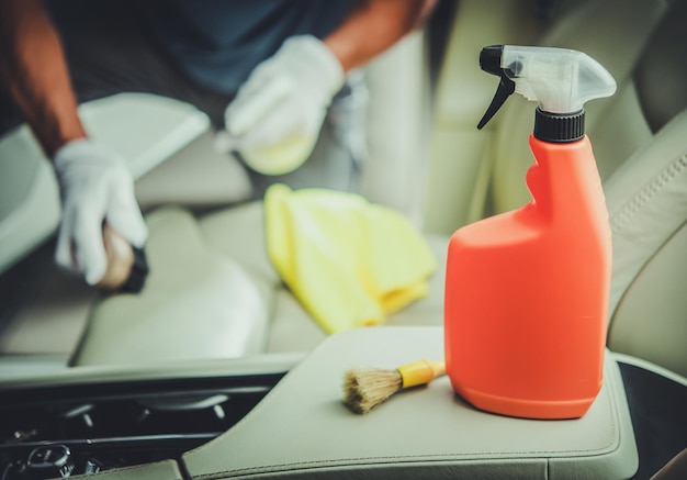 Hombres caucásicos limpiando el interior del vehículo utilizando detergente desinfectante especializado Mantenimiento del interior del coche