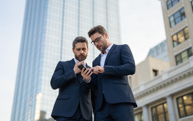 Hombres comerciantes que trabajan independientemente en línea al aire libre comerciantes hombres de negocios que trabajan independientemente en línea con teléfono