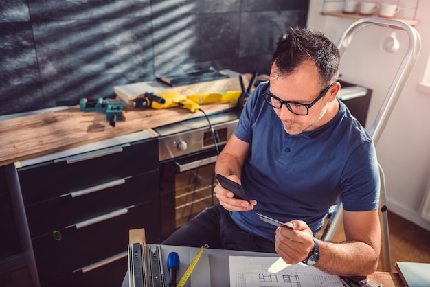 Hombres comprando en línea durante la renovación de la cocina