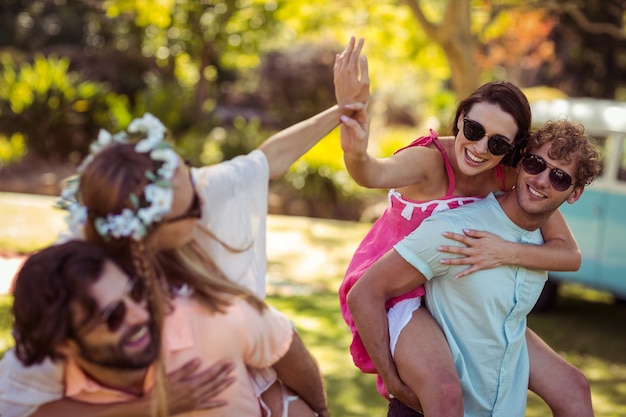 Foto hombres dando paseos a cuestas a mujeres