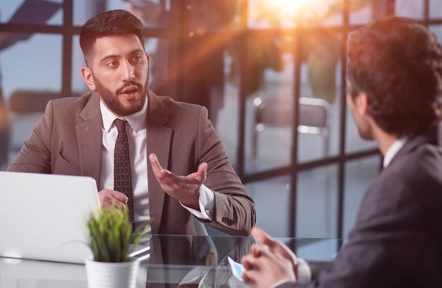 Hombres en una discusión de gestión o consultoría en la mesa hablando y trabajando en equipo