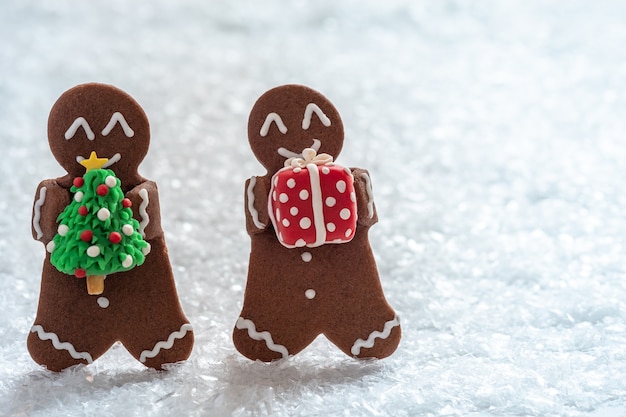 Hombres divertidos de galletas de jengibre con muñeco de nieve de mazapán pequeño