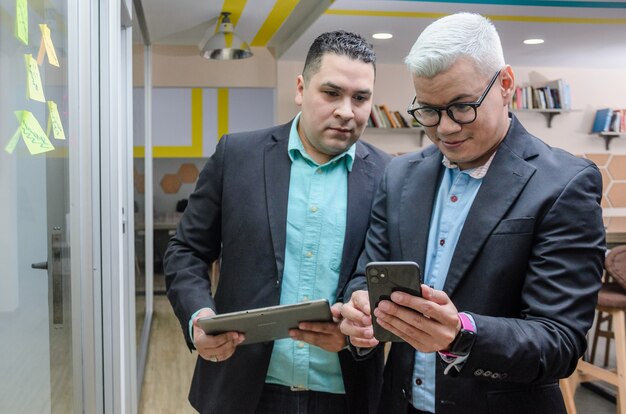 Hombres ejecutivos revisando notas en tableta