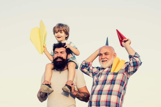 Hombres emocionados Vacaciones familiares y unión Libertad para soñar niño alegre jugando con avión contra el cielo efecto vintage