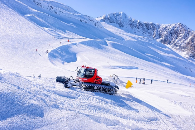 Hombres esquiadores y practicantes de snowboard en el glaciar Hintertux en Tirol en Mayrhofen, Alpes invernales. Personas con esquí y snowboard en Hintertuxer Gletscher en montañas alpinas. Snowcat ratrack trabajando en segundo plano