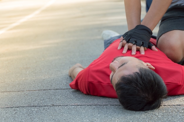 Los hombres están haciendo RCP para un amigo que tiene un ataque al corazón