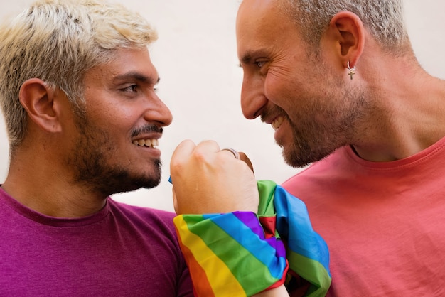 Hombres felices unidos con bandera LGBT