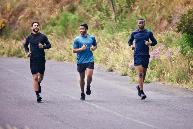 Foto hombres fitness y amigos corriendo en un camino para entrenar velocidad y energía, salud y rutina cardiovascular en la naturaleza diversidad deportiva y grupo de hombres en carrera de práctica para entrenamiento de competencia o meta de carrera