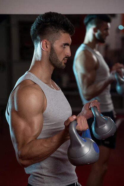 Hombres en el gimnasio haciendo ejercicio con Kettle Bell