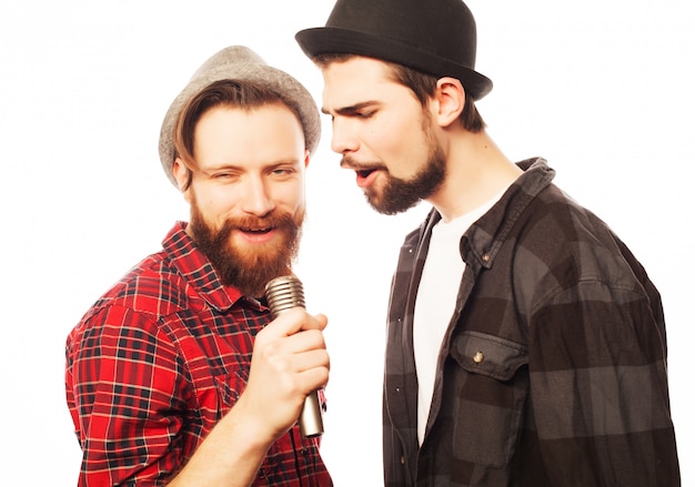 Foto hombres jóvenes cantando con micrófono