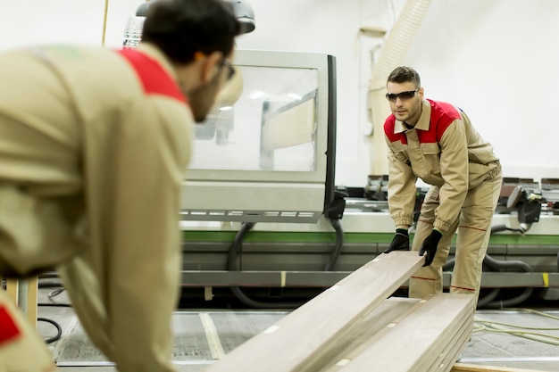 Hombres jóvenes que trabajan en la fábrica de muebles