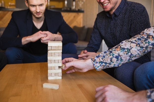 Hombres jugando un juego con bloques de madera.