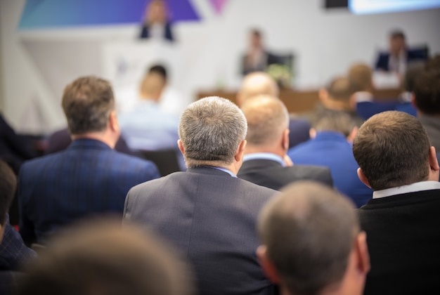 Hombres maduros sentados atrás en la conferencia de negocios.