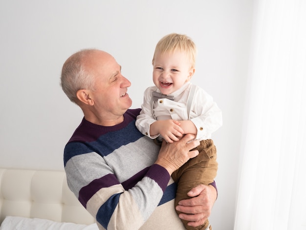 Hombres mayores guapos felices con su adorable nieto interior