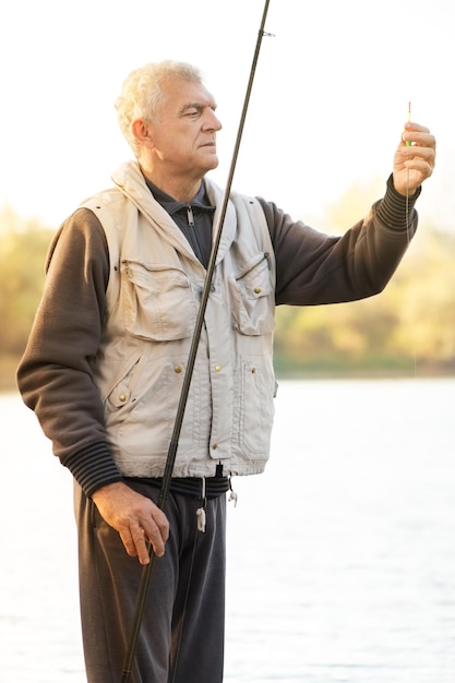 Foto hombres mayores pescando junto al lago.