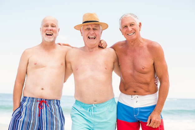 Hombres mayores de pie en la playa