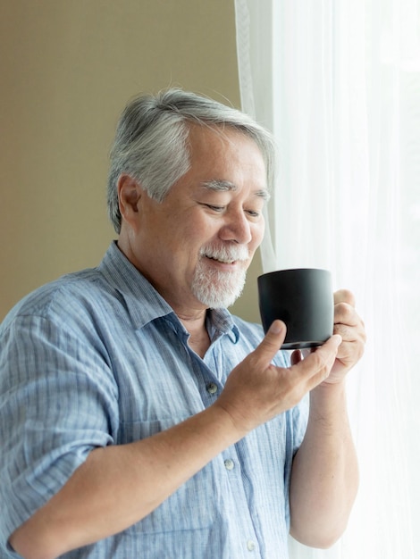 Los hombres mayores se sienten felices bebiendo café por la mañana disfrutando del tiempo en su casa interior fondo estilo de vida concepto de felicidad senior