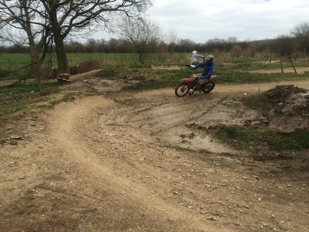 Foto hombres montando motocicletas en el campo contra el cielo