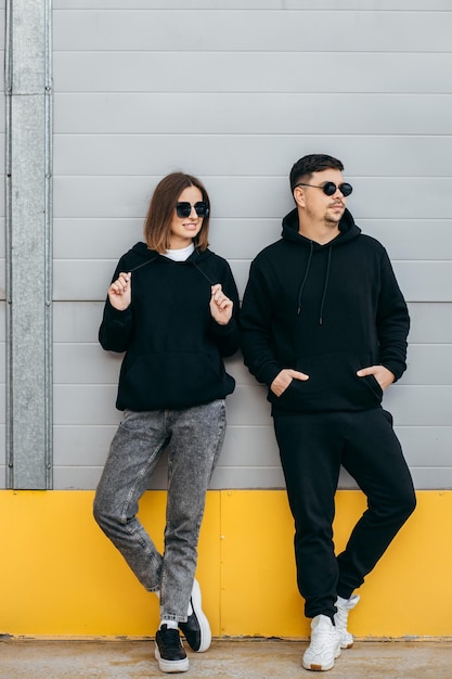 Foto hombres y mujeres adultos jóvenes con gafas y sudaderas con capucha negras