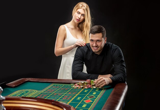 Hombres con mujeres jugando a la ruleta en el casino.