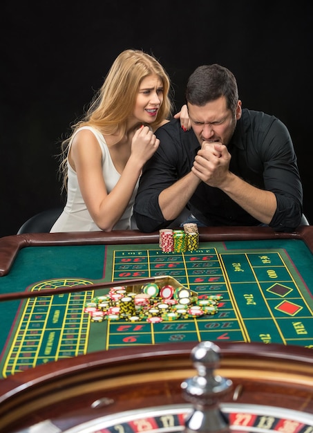 Hombres con mujeres jugando a la ruleta en el casino.