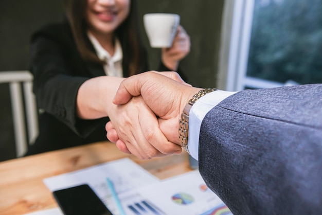 Hombres y mujeres de negocios se dan la mano en la oficina Trabajo en equipo colaborativo Concepto de éxito empresarial