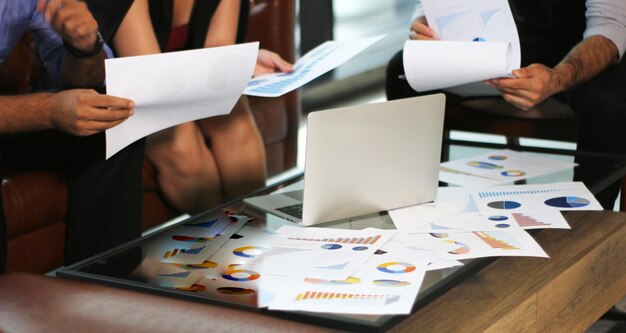 Foto hombres y mujeres de negocios reunidos con el plan de negocios en la oficina