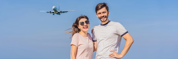 Hombres y mujeres turistas se divierten en la playa viendo los aviones aterrizando en un avión