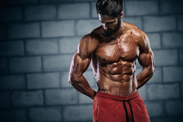 Hombres musculosos guapos posando y flexionando los músculos