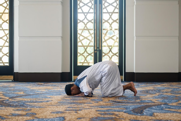 Foto hombres musulmanes rezando en sujud o postura de postración concepto islámico