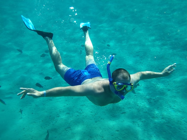 Hombres nadan bajo el agua en máscaras sobre el mar.