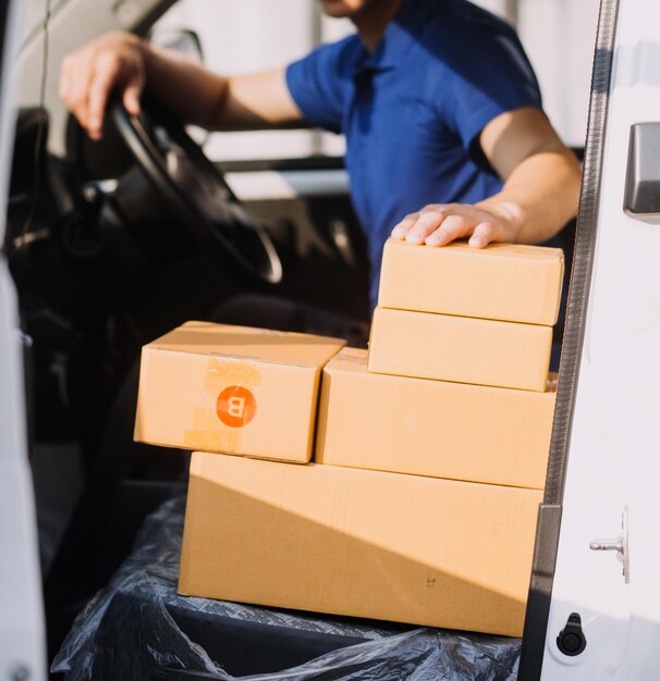 Foto los hombres de negocios asiáticos usan una computadora portátil para verificar las cajas de envío en línea del pedido del cliente en el hogar.