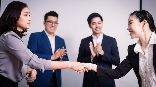 Hombres de negocios dándose la mano, entre la reunión en la sala de seminario