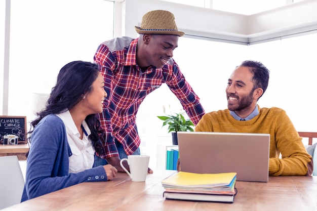 Hombres de negocios felices que discuten con uno a en la oficina creativa