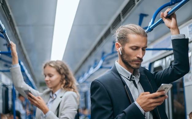 hombres de negocios jóvenes que viajan en el metro.